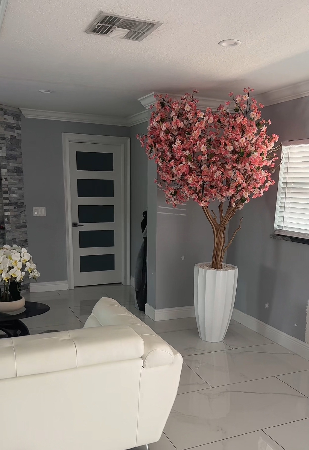 Rosa Kirschblütenbaum in einer weißen abgeschrägten Vase